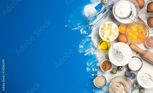 Baking ingredients on blue color background, top view