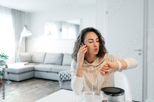 Portrait of woman looking at her smartwatch at home photo