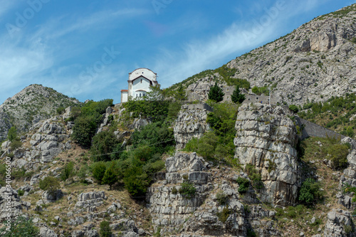 Eine kleine Kirche im grünen auf einem Berg mit blauem Himmel 