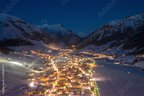 Italy, Province of Sondrio, Livigno, Aerial view of?illuminated?town in Italian Alps at dusk