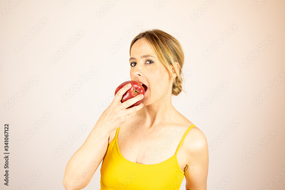 Healthy beautiful woman taking a bite of an apple Healthy beautiful woman taking a bite of an apple