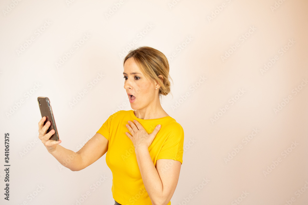 Healthy beautiful woman looking shocked into her phone Healthy beautiful woman looking shocked into her phone