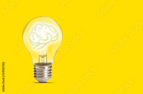 Lamp bulb with human brain inside on yellow background, space for text. Idea generation