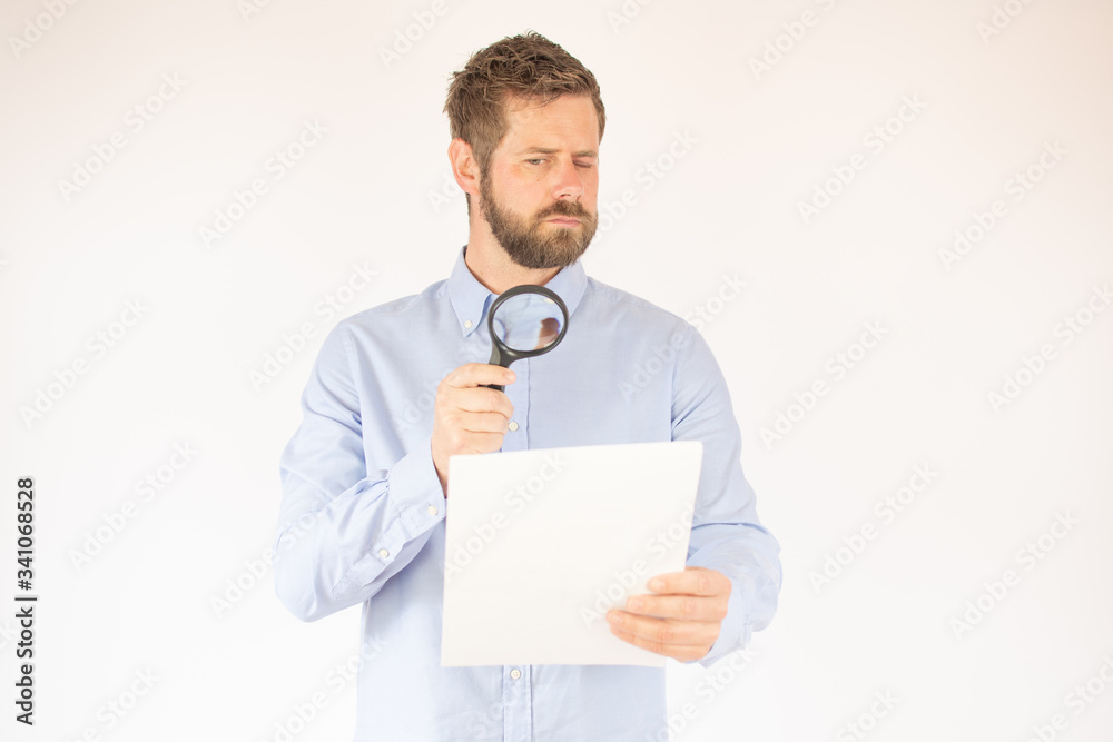 handsome young man in blue shirt reading a document handsome young man in blue shirt reading a document