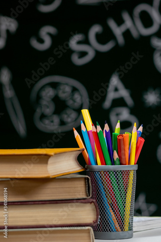 Back to school background with books, pencils and apple on white table.