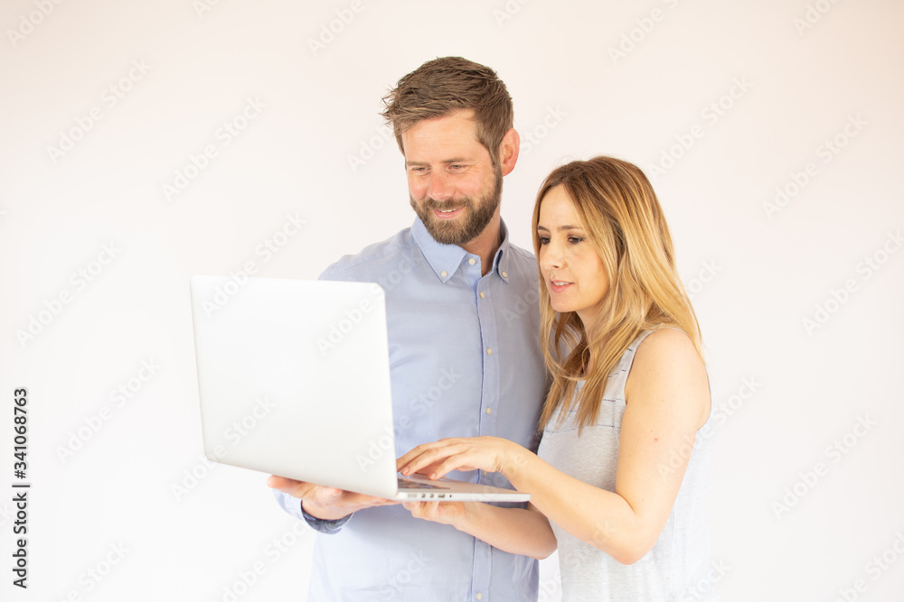 handsome couple is looking at their laptop