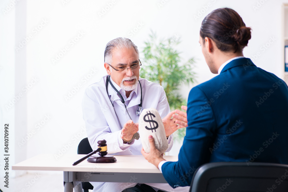Male doctor in courthouse meeting with lawyer Male doctor in courthouse meeting with lawyer