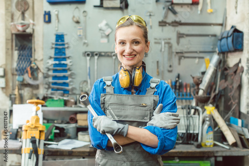 Woman metalworker with tool posing for the camera photo