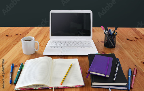 tidy workspace for working or studyng online at home with a laptop computer  notebooks  cup of coffe on a wooden desk table - telecommuting background wallpaper for a lockdown