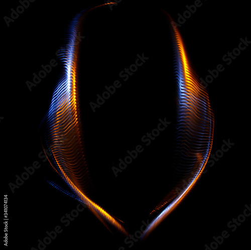 Long exposure photograph of multicolored light trails forming a complex twisted geometric pattern of parallel lines against a dark background. Only photo, no illustration.