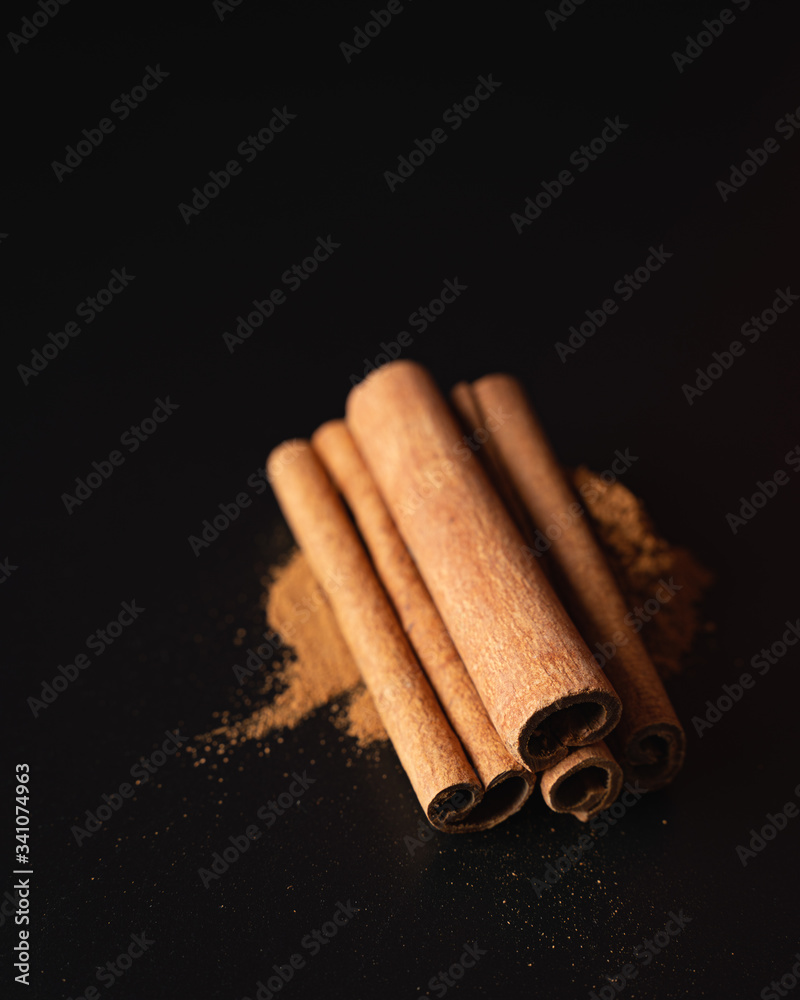 Cinnamon sticks and powder on dark background
