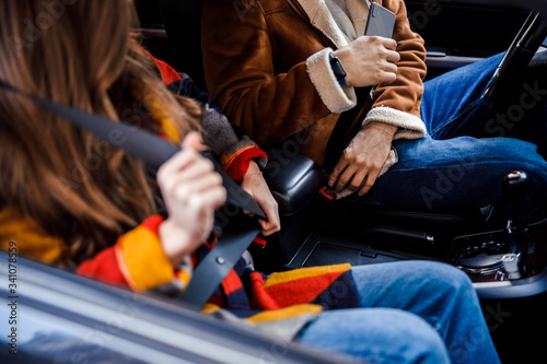 Two people in the car fastening seat belts stock photo