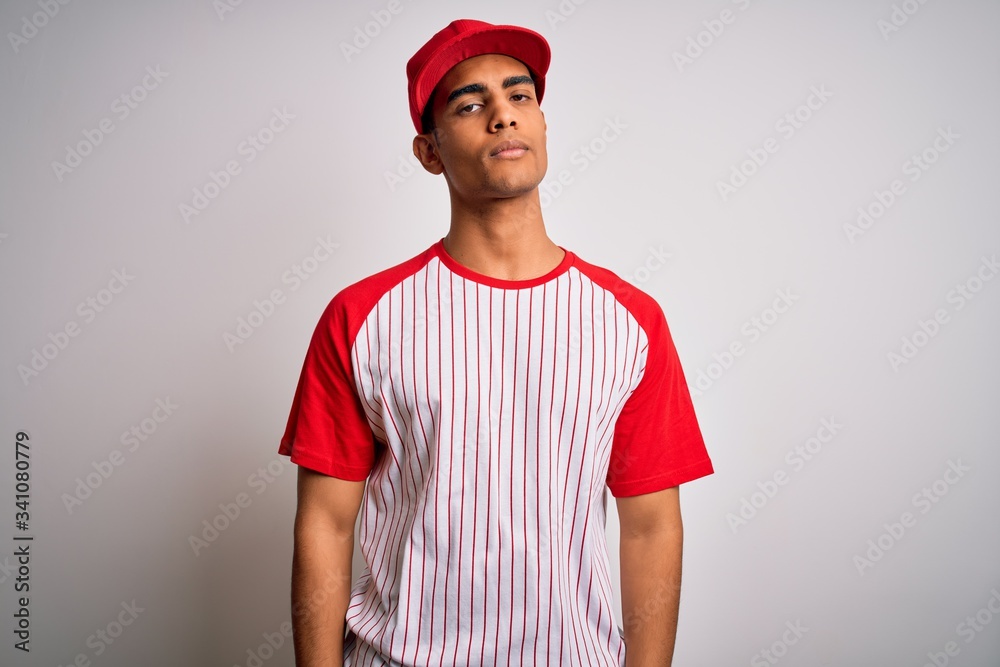 Young handsome african american sportsman wearing striped baseball t-shirt and cap looking sleepy and tired, exhausted for fatigue and hangover, lazy eyes in the morning.