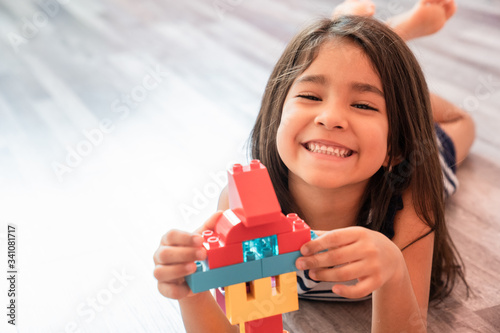 Little Girl Playing With Construction Blocks at Home