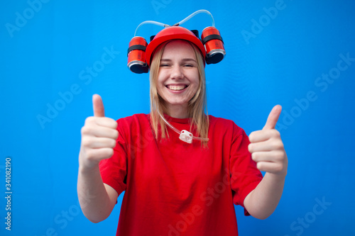 happy funny girl fan in red uniform and beer hat shows likes and smiles, joyful cheerleader shows a good gesture
