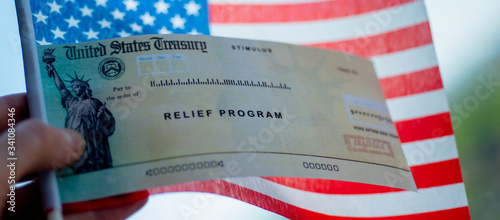Fotografie COVID-19 economic Stimulus check on blurred USA flag background