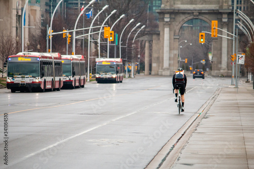 Cyclist biking through The Exhibition Centre in Toronto. Empty streets. Covid-19.