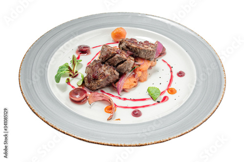 veal medallions with vegetables on a white background