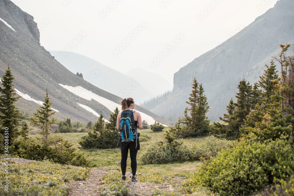 female traveler and photographer hiking in the mountains of Colorado