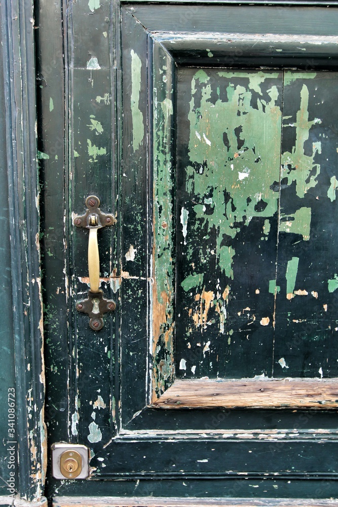 Old and damaged wooden door with forged details in Spain