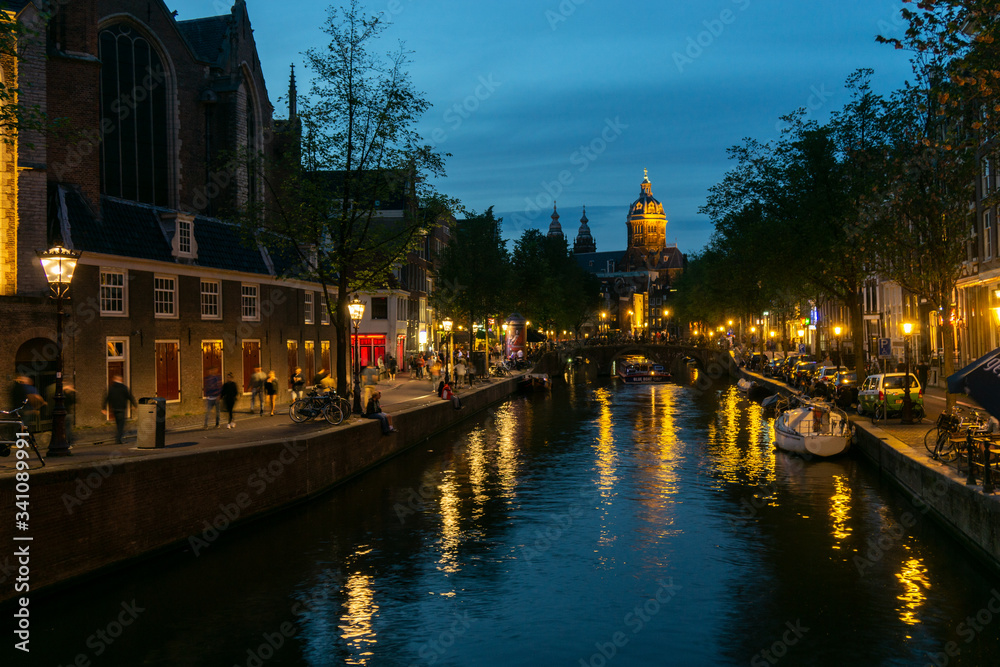 Amsterdam canal evening view with houses and illumination