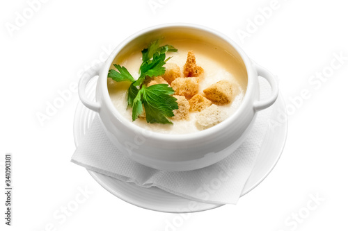 Homemade vegetable cheese soup with bread crumbs and greens on a white background. Isolated object