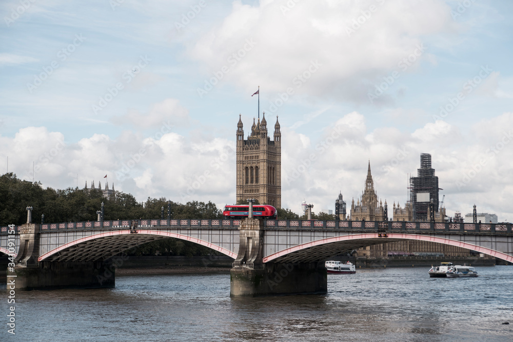 Obraz premium red double decker bus going over bridge in front of london tower