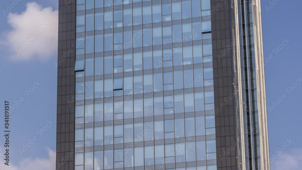 Zoom out time lapse of moving clouds reflection in skyscraper windows glass Zoom out time lapse of moving clouds reflection in skyscraper windows glass