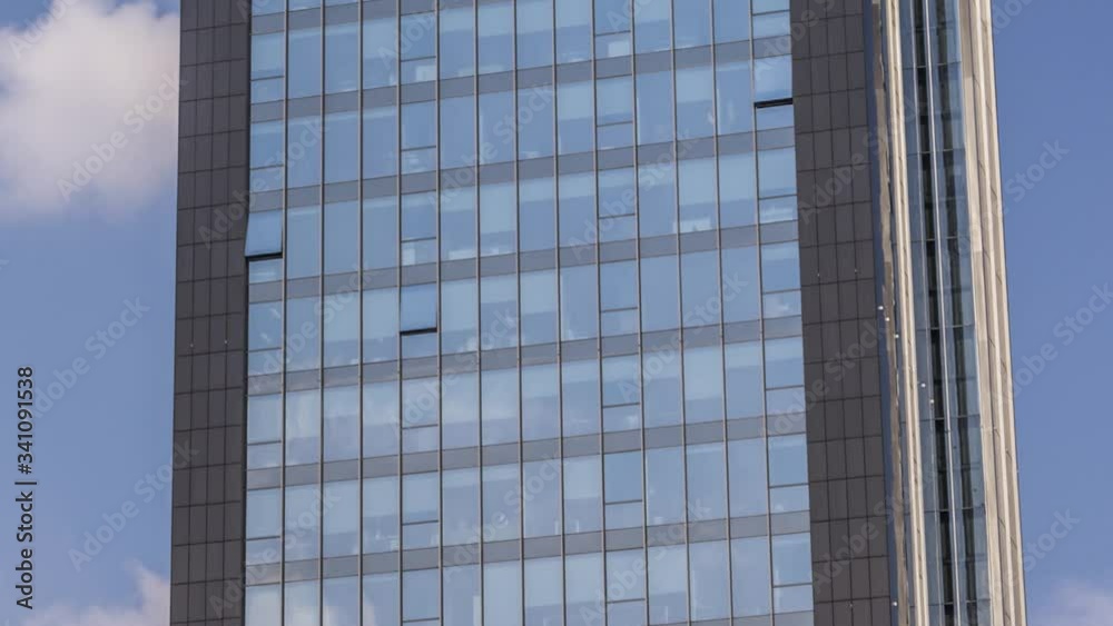 Zoom in time lapse of moving clouds reflection in skyscraper windows glass Zoom in time lapse of moving clouds reflection in skyscraper windows glass