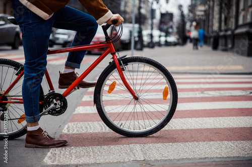 Cycler waiting on the pedestrian crossing to continue his trip