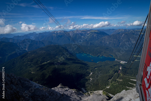 Image, through mountain cable car window. The Seilbahn Zugspitze is an aerial tramway running from the Eibsee Lake to the top of Zugspitze. View from above to the peaks of Alpine Mountains.