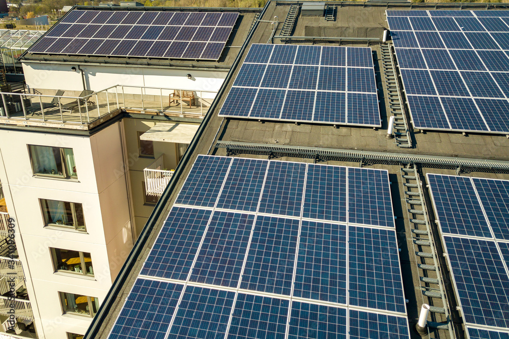 Aerial view of solar photovoltaic panels on a roof top of residential building block for producing clean electric energy. Autonomous housing concept. Aerial view of solar photovoltaic panels on a roof top of residential building block for producing clean electric energy. Autonomous housing concept.