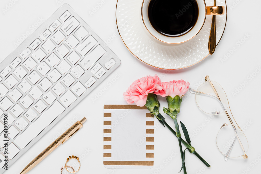 Pink and gold office details with electronics and desk accessories in a white background Pink and gold office details with electronics and desk accessories in a white background