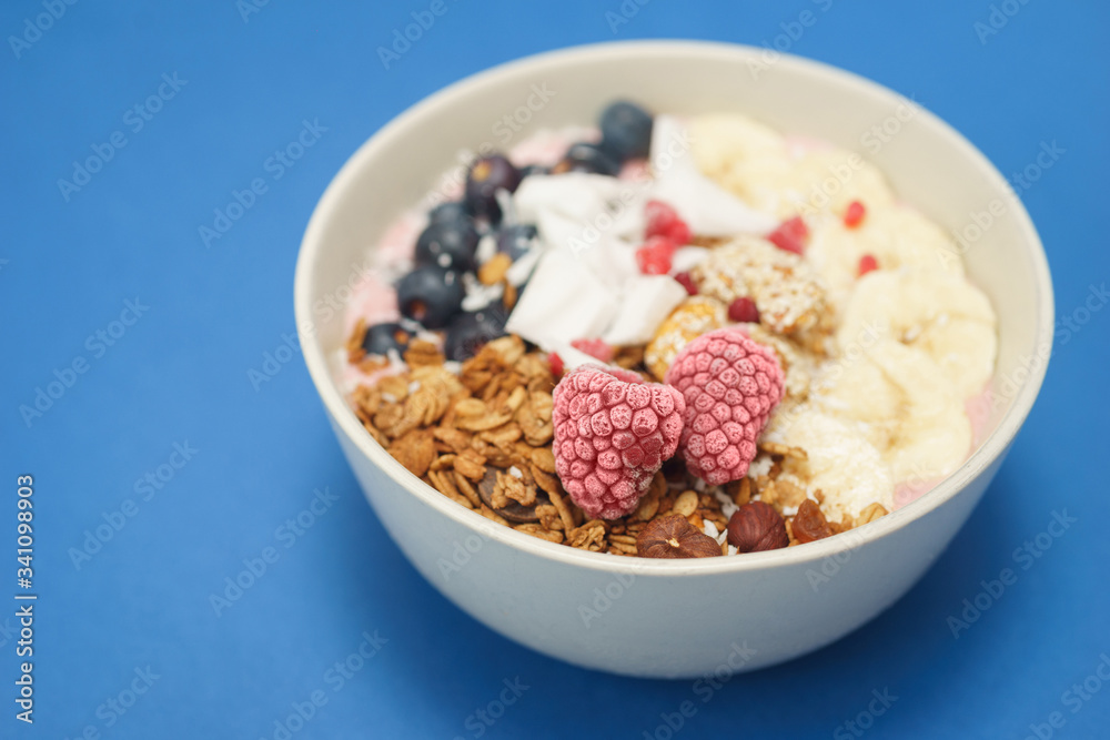 Handmade Bowl healthy tasty breakfast of yogurt, smoothie with granola, nuts, bananas and berries Handmade Bowl healthy tasty breakfast of yogurt, smoothie with granola, nuts, bananas and berries