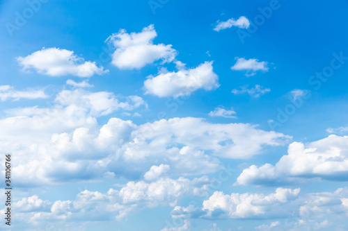 Cloudscape. Blue sky with large and small white clouds. Beautiful clouds slowly float against the blue sky.