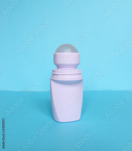 White bottle with Body antiperspirant deodorant roll-on on blue background.