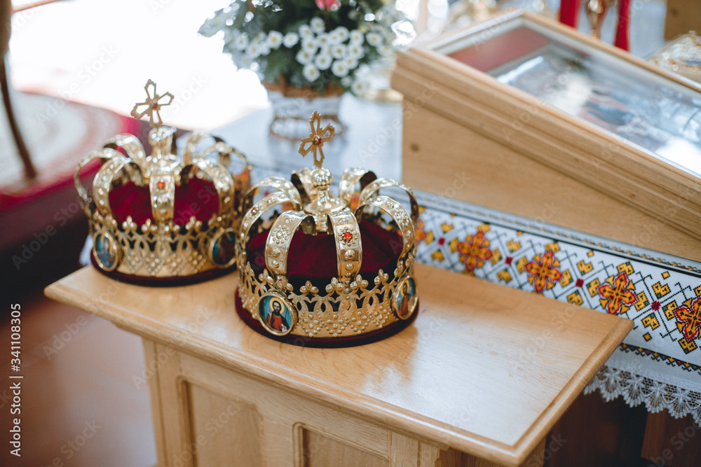 Naklejka premium Orthodox wedding crowns, church icons, church books, gospel on the table