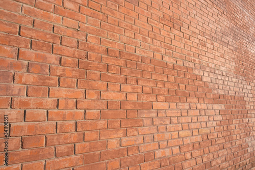 Brick wall, an angled view, lit with warm light.