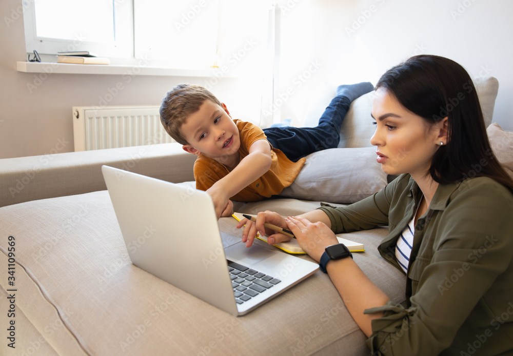 Cute little boy and his mother using laptop at home Cute little boy and his mother using laptop at home