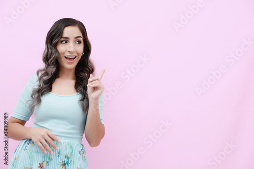 Young woman over isolated pink background doing happy gesture © Javier