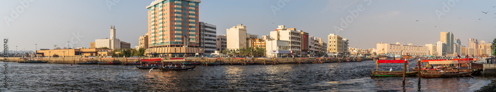 Dubai Creek panorama with river, traditional taxi boats and buildings, United Arab Emirates.