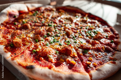 Hot tasty pizza ready to eat. Pizza in a cardboard box against a sunny background. Pizza delivery. Pizza menu.