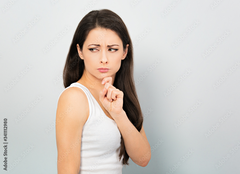 Concentrated young woman casual clothing with hand under the face find the solution on problem situation. Corona virus. Working at home. Studio portrait Concentrated young woman casual clothing with hand under the face find the solution on problem situation. Corona virus. Working at home. Studio portrait