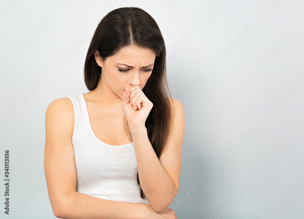 Beautiful unhappy crying business woman in white shirt with hand under the face and looking serious on blue background. Closeup Beautiful unhappy crying business woman in white shirt with hand under the face and looking serious on blue background. Closeup
