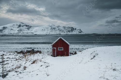 Red cabin on a snowy shore
