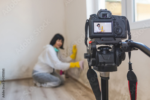 Video camera filming how clever woman cleaning mold from wall using spray bottle.