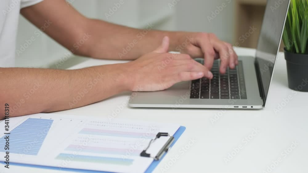 Young man working in bright office at laptop Young man working in bright office at laptop