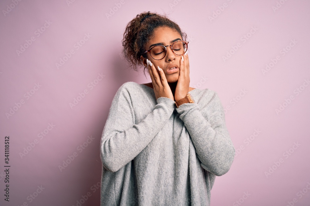 Young beautiful african american girl wearing sweater and glasses over pink background Tired hands covering face, depression and sadness, upset and irritated for problem Young beautiful african american girl wearing sweater and glasses over pink background Tired hands covering face, depression and sadness, upset and irritated for problem