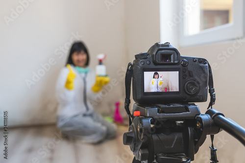 Video camera filming woman cleaning mold from wall using spray bottle and showing gestures thumbs up
