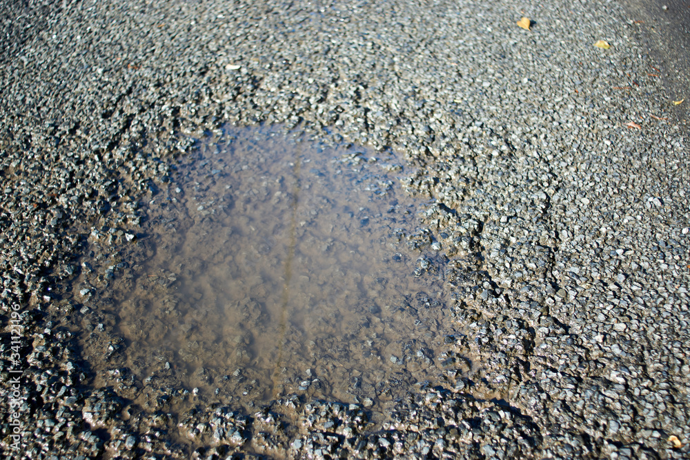 Obraz premium 舗装道路・窪み・水溜り・アップ